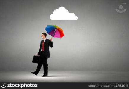 Defend your business. Businessman standing with umbrella under cloud concept