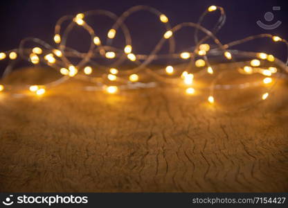 Defocus christmas lights on wooden background. selective focus on wood planks