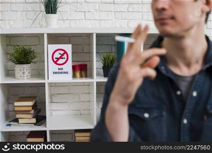 defocus man with cigarette front no smoking poster shelf