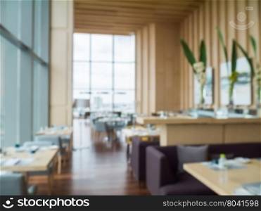 Defocus of modern restaurant of hotel with wooden furniture