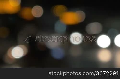 Defocus of traffic in the city late in the evening. Blurred people and lights of cars passing by