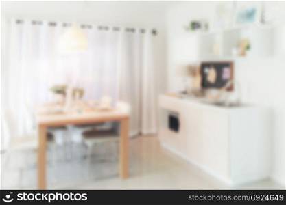 Defocus wooden dining table next to pantry in modern kitchen