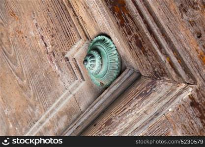 defocused abstract rusty brass brown knocker in a door curch closed wood lombardy italy varese lonate pozzolo