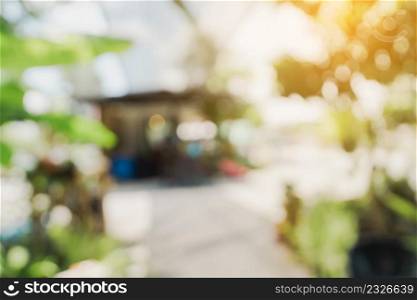defocused bokeh and blur background of garden trees in coffee shop with sunlight.