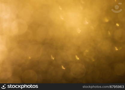 Defocused Bokeh twinkling lights Vintage background. Festive background with natural bokeh and bright golden lights.