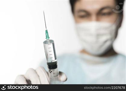 defocused doctor holding syringe