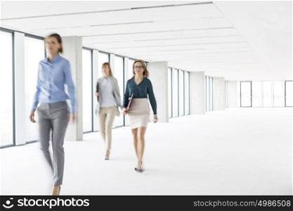 Defocused image of businesswomen walking in empty new office