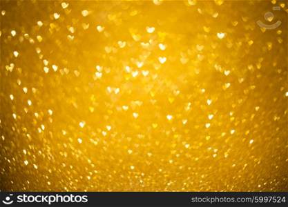 Defocused light in heart shape bokeh background for design. Hearts gold bokeh