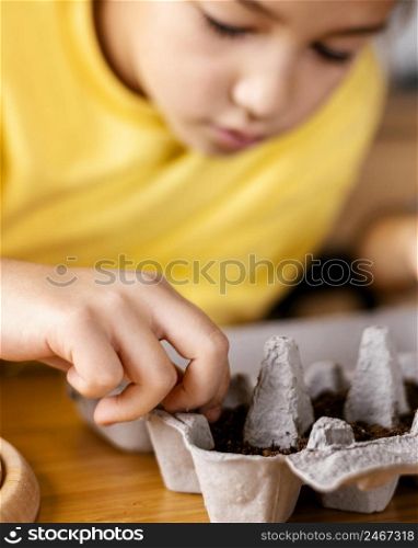 defocused little girl planting seeds home