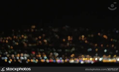 Defocused loop video of colorful city lights at night. Multicolor twinkling dots on black background. Can be used as background