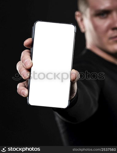 defocused male rugby player holding smartphone