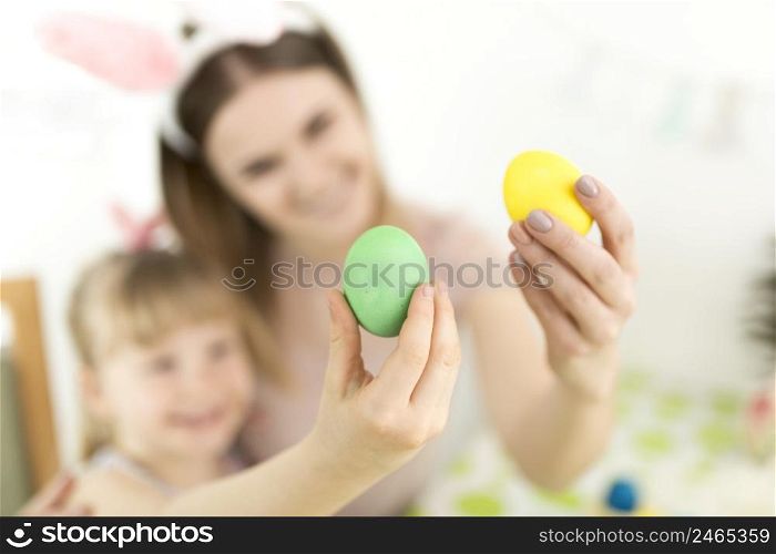 defocused mom daughter with aster eggs