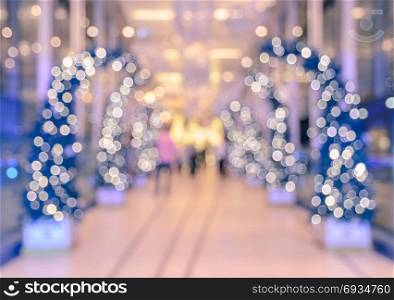 Defocused office, hotel lobby or shopping mall building indoor background with Christmas light illuminated on tree