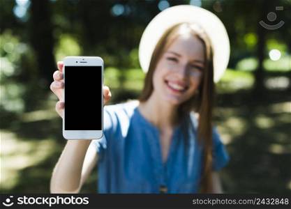 defocused woman holding mockup smartphone