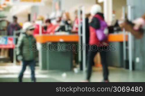 Defocusing shot of people paying at ther cashdesk in the supermarket, other entering the shop