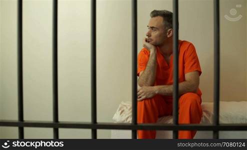 Dejeacted inmate sits behind bars in prison