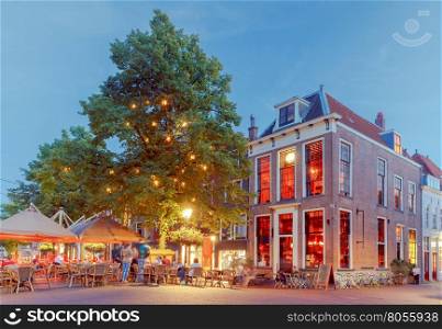 Delft. City street in night light.. Old medieval street with traditional Dutch houses at sunset. Delft. Netherlands.