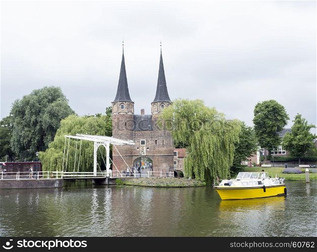 delft, netherlands, 30 june 2017: yellow boat waits for bridge to open near oostpoort in old dutch town of delft