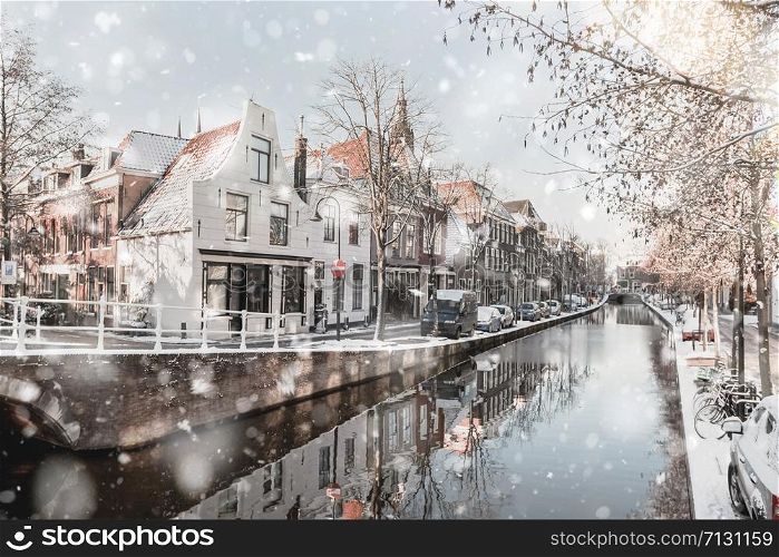 Delft Netherlands Houses and Canal in residential district view at winter snowstorm. Pastel trendy toning. Beautiful inspiring moody faded scenery