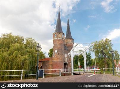Delft. Old City Gates.. The old medieval city gate with two stone towers and bridge in Delft. Netherlands
