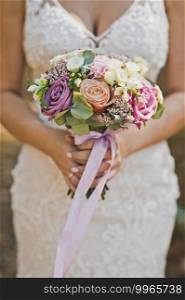Delicate bouquet of pink and white flowers in the hands of the bride.. Beautiful bride bouquet in her hands close - up 2200.