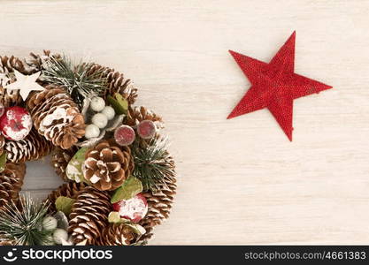 Delicate Christmas wreath of pine cones and a red star on gray wooden background