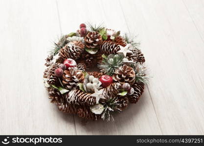 Delicate Christmas wreath of pine cones on gray wooden background