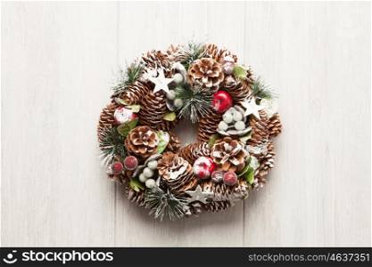 Delicate Christmas wreath of pine cones on gray wooden background