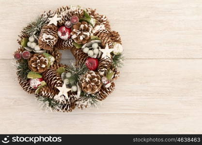 Delicate Christmas wreath of pine cones on gray wooden background