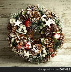 Delicate Christmas wreath of pine cones on gray wooden background