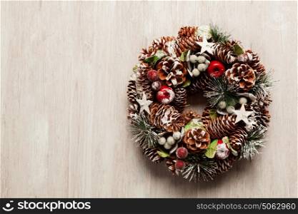 Delicate Christmas wreath of pine cones on grey wooden background