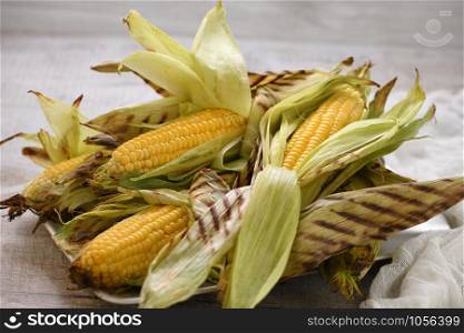 Delicate, juicy corn on the cob in husk cooked grilled
