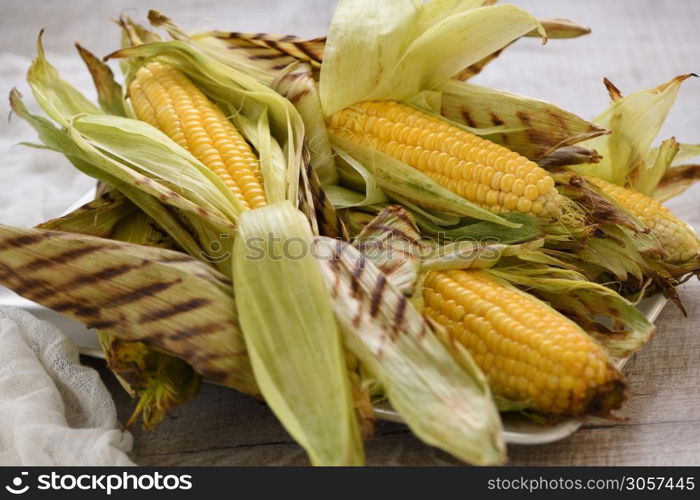 Delicate, juicy corn on the cob in husk cooked grilled