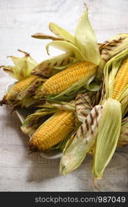 Delicate, juicy corn on the cob in husk cooked grilled
