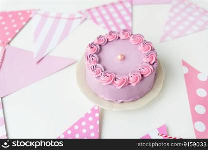 Delicate lavender pink bento cake on a plate against a background of flags for a party. Celebration, happy day. Delicate lavender pink bento cake on a plate against a background of flags for a party. Celebration, happy day.