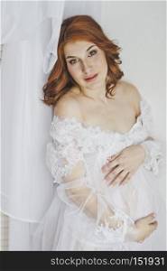 Delicate pregnancy in white robes.. Red-haired pregnant girl in a white robe 6851.