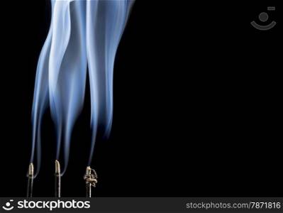 delicate smoke plumes from burning incense sticks with a copy space