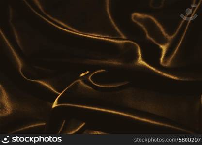 delicate waves of golden satin silk close up