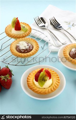 Delicious and decadent cream and chocolate tarts with fresh strawberries.