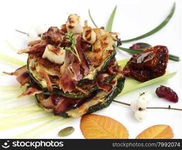 Delicious appetizer with fried potato pancakes, zucchini slices and crispy bacon