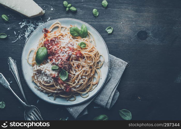 delicious appetizing classic spaghetti pasta with tomato sauce, parmesan cheese and fresh basil, top view