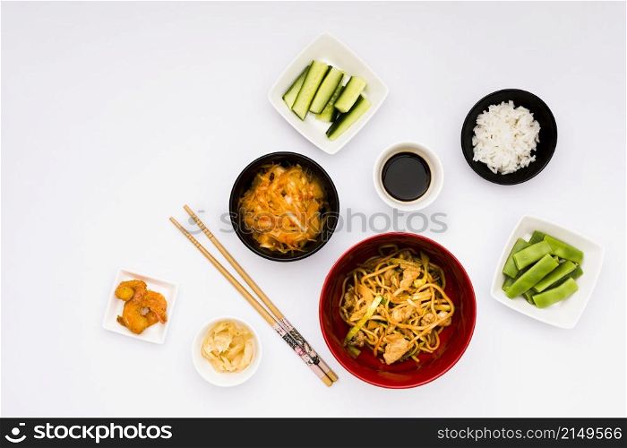 delicious asian food with ingredients arranged white backdrop