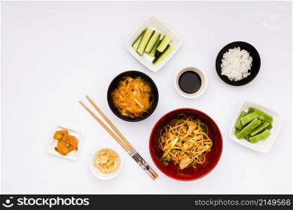 delicious asian food with ingredients arranged white backdrop