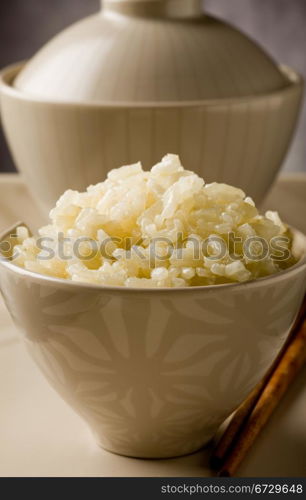 delicious asian rice plate with chopsticks on glass table
