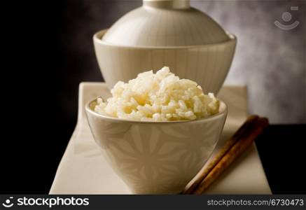 delicious asian rice plate with chopsticks on glass table