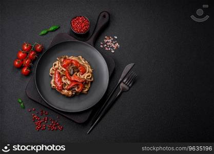 Delicious asian udon dish with vegetables, mushrooms, salt and spices on a ceramic plate on a dark concrete background