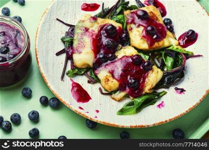 Delicious baked fish with berry sauce. Stewed pangasius with blueberries. Baked fish,pangasius on white plate