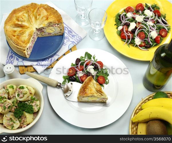 Delicious baked ham and egg pie with potato and salad ready to serve.