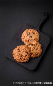 Delicious baked oatmeal raisin cookies on a dark concrete background. Sweets for breakfast