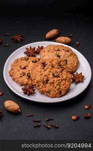 Delicious baked oatmeal raisin cookies on a dark concrete background. Sweets for breakfast